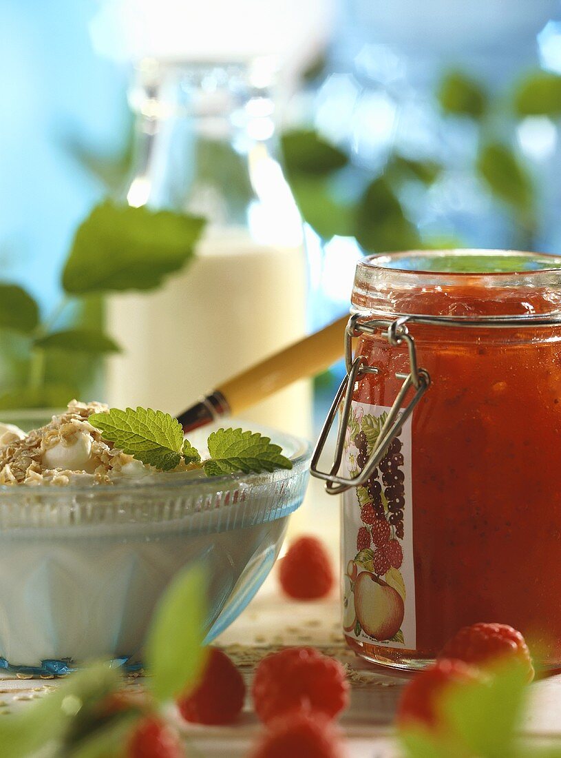 Müsli mit Haferflocken und rote Marmelade im Einmachglas