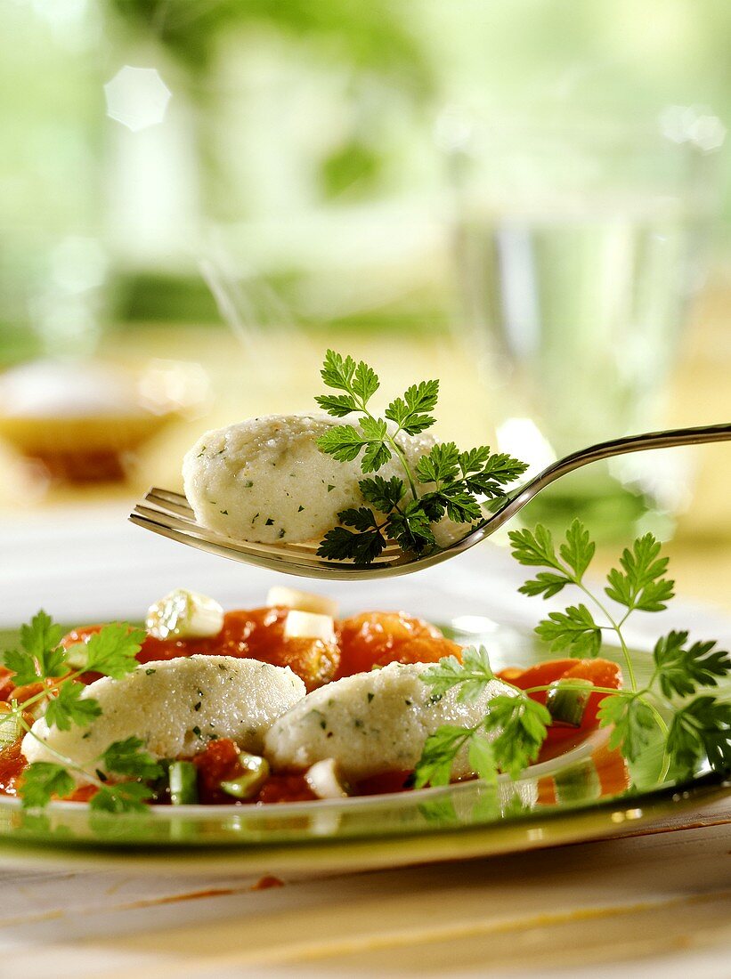 Herb quark dumplings with tomato sugo on plate and fork