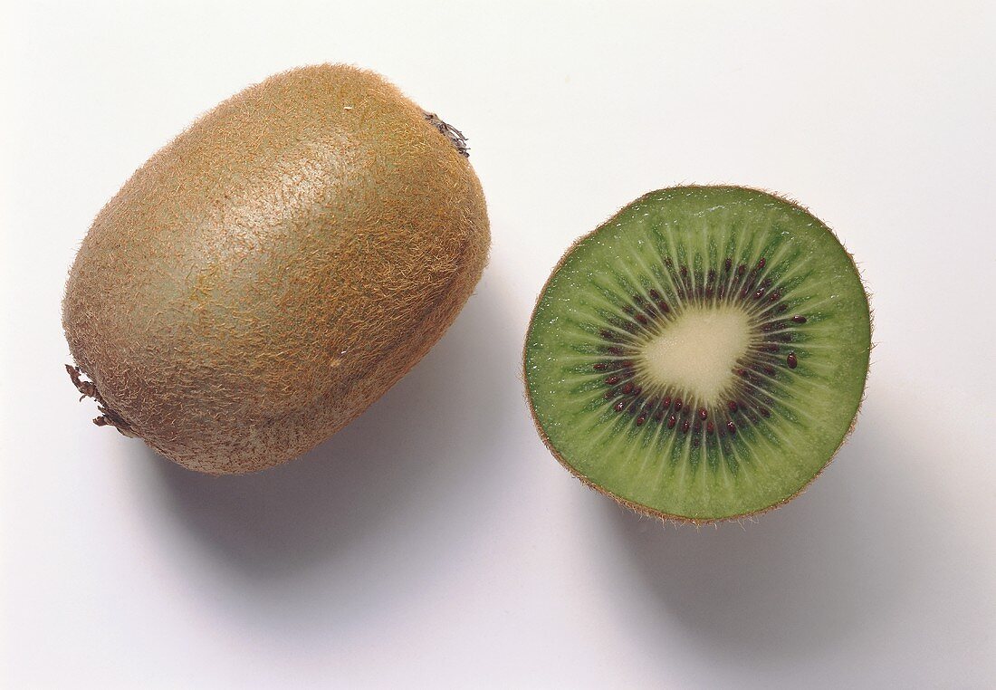Whole and half kiwi fruit on white background