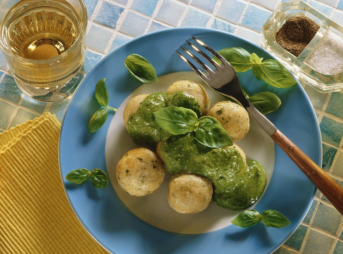 Polenta dumplings with pesto and basil leaves