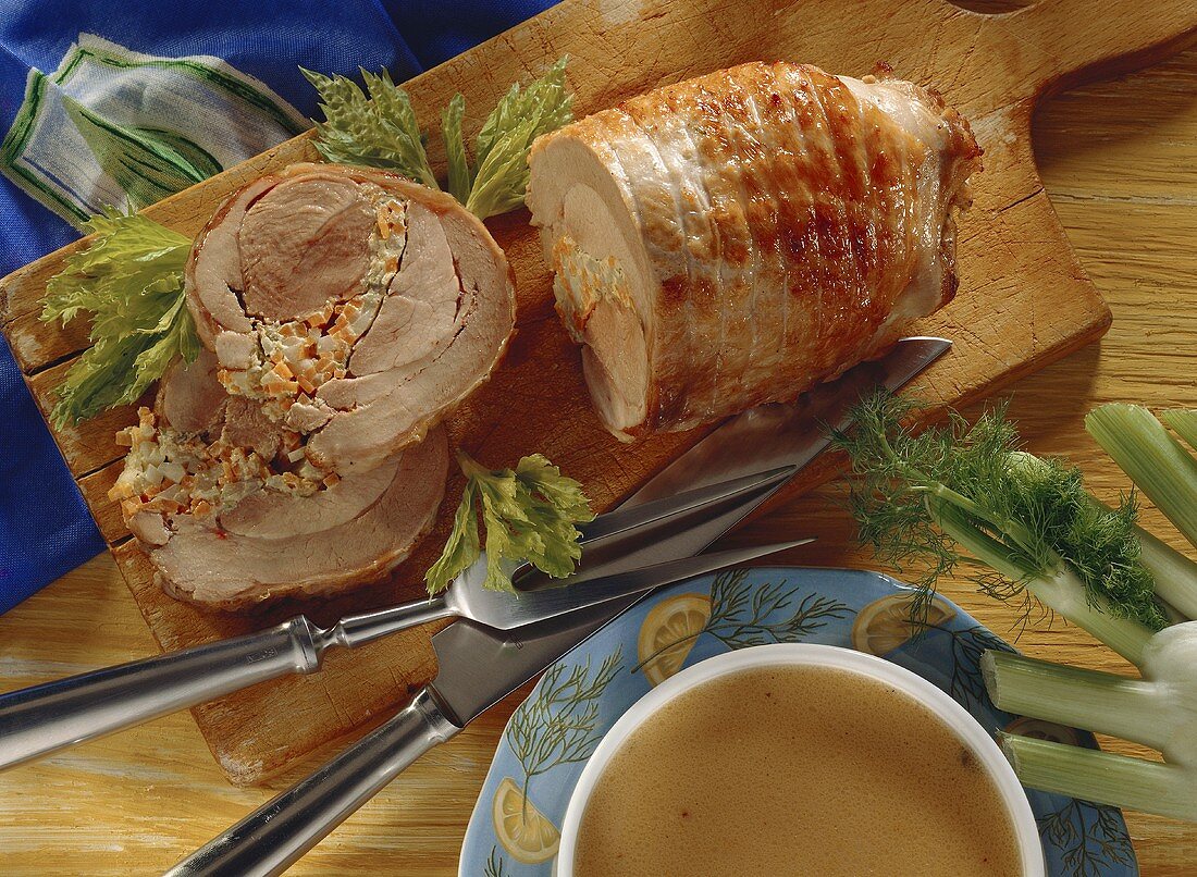 Turkey roll with vegetable stuffing on chopping board