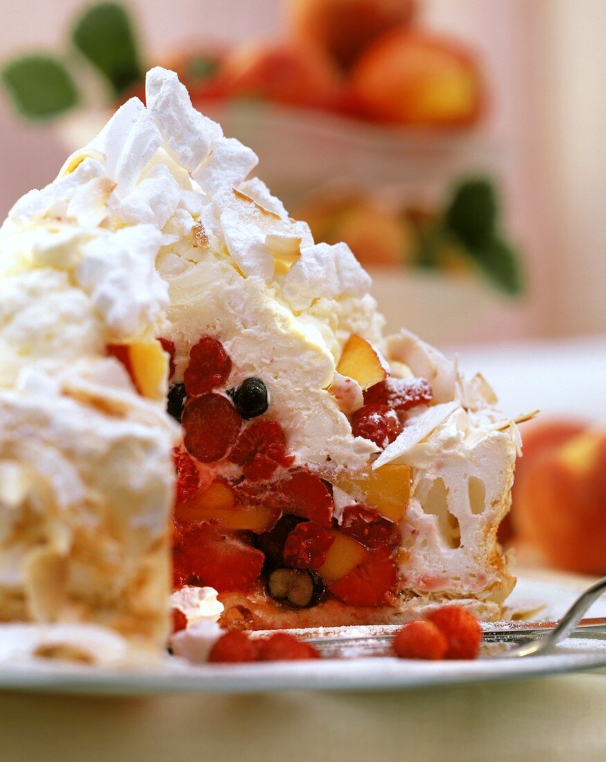 Coconut meringue gateau with summer fruit on plate