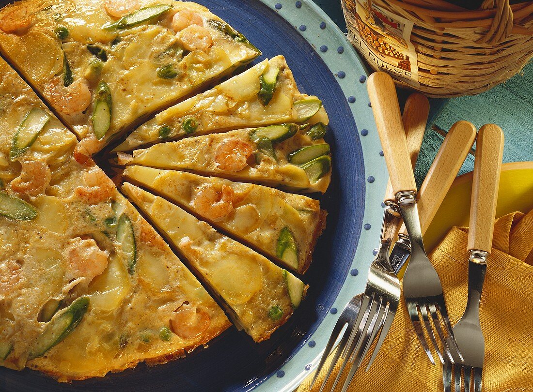 Grüne Spargel-Tortilla mit Garnelen auf Teller