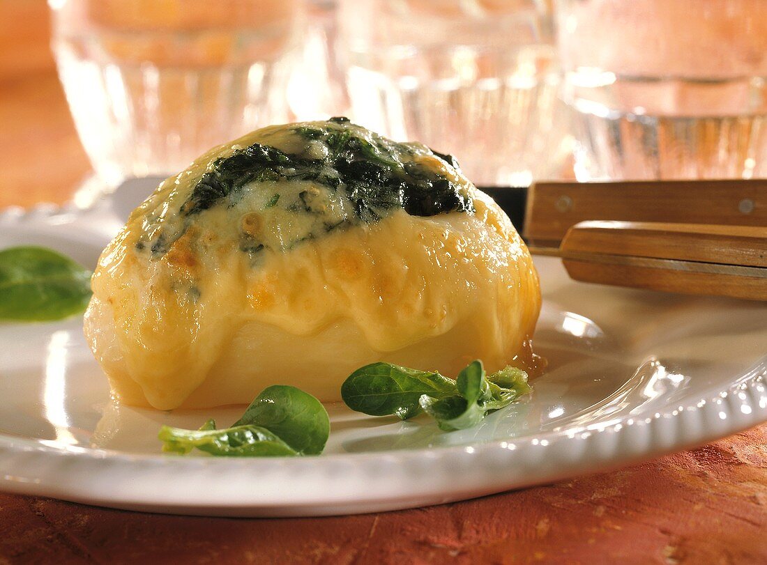 Potatoes stuffed with spinach & cheese on white plate