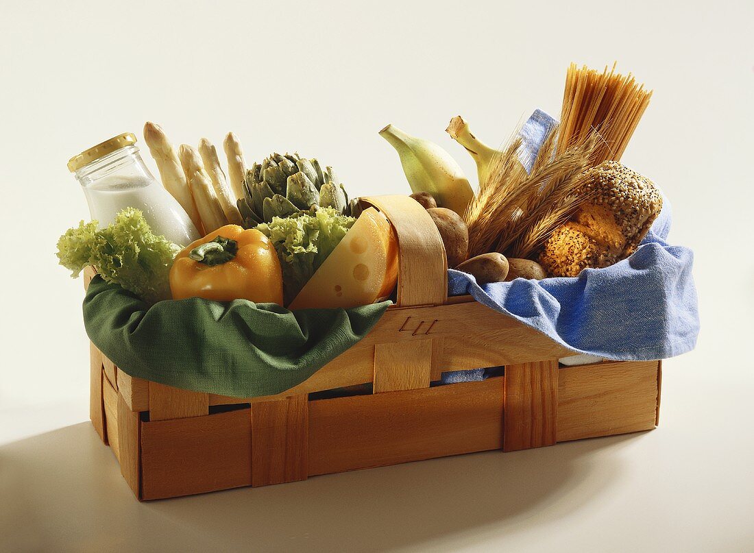 Bread, pasta, bananas, vegetables, milk & cheese in basket