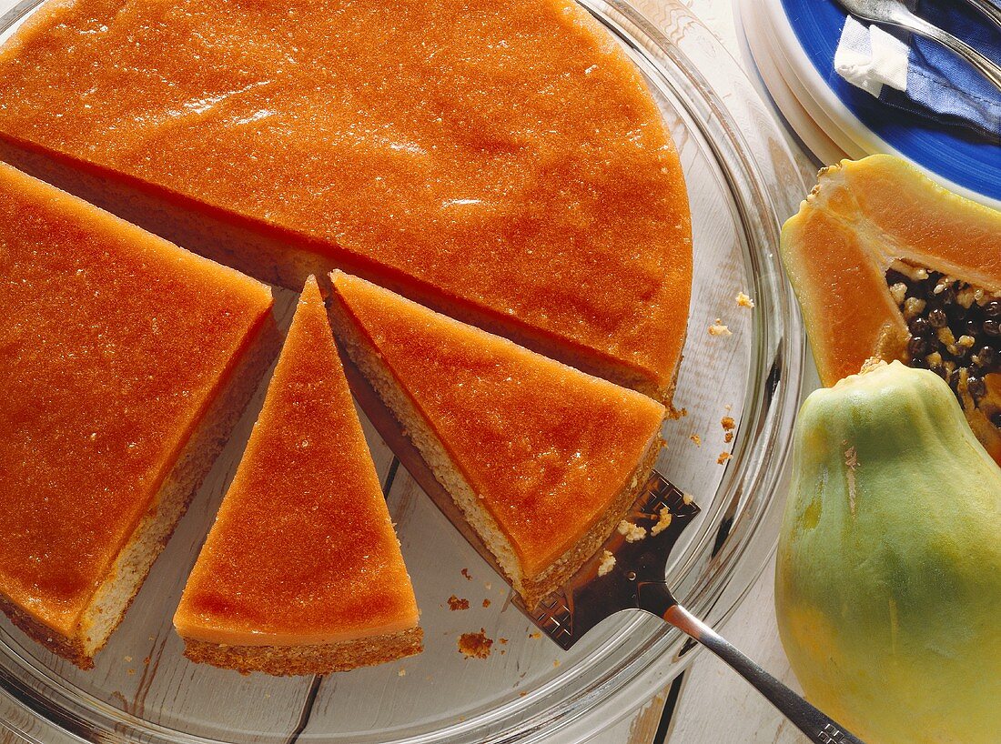 Almond and papaya cake, pieces cut, on glass plate