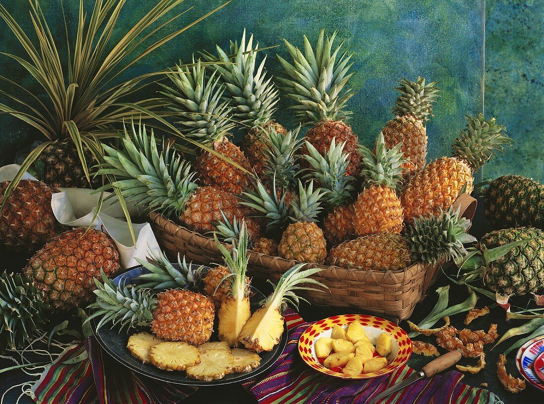 Ananasstilleben mit verschiedenen Sorten, ganz, angeschnitten