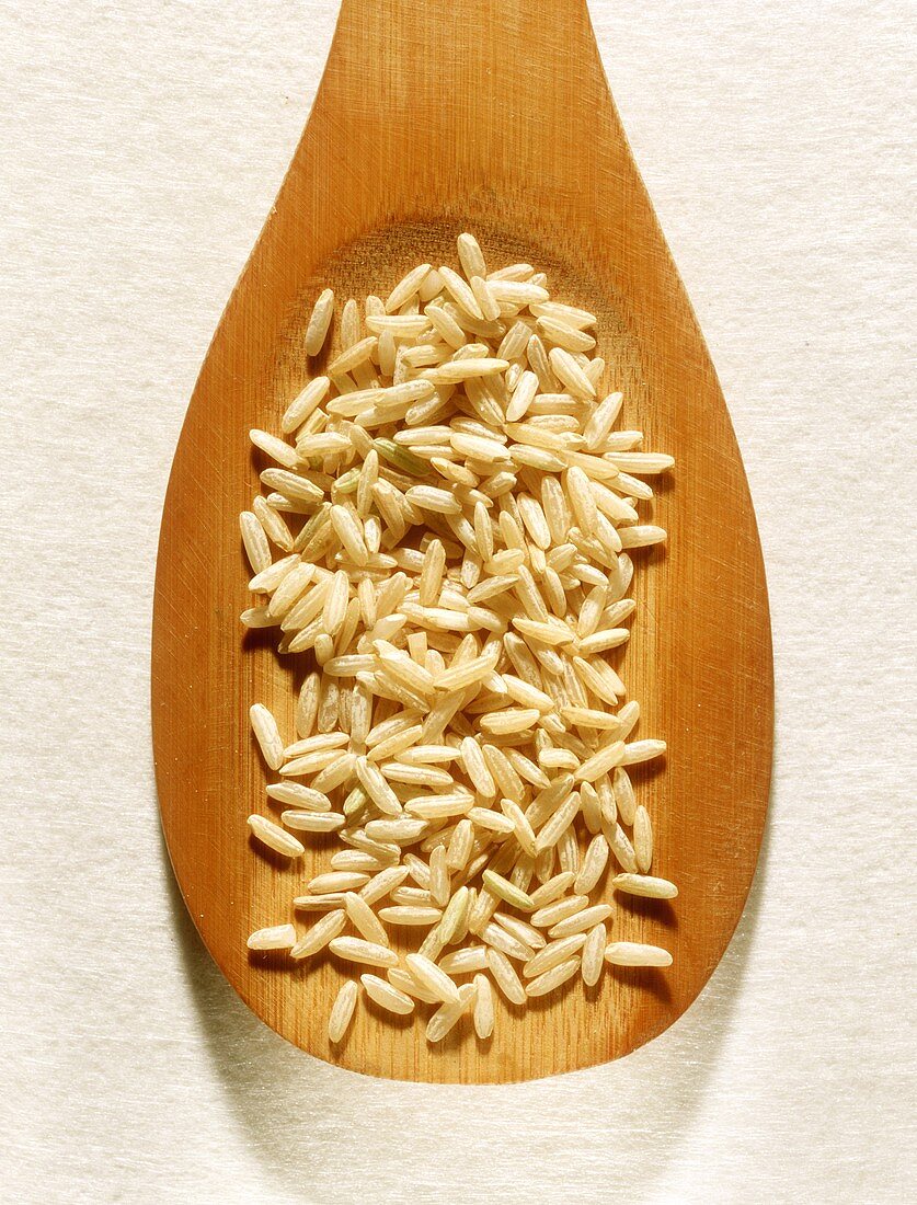 Unpolished rice on a wooden spoon