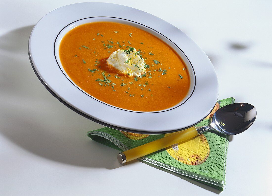 Carrot soup with curried cream and chopped parsley