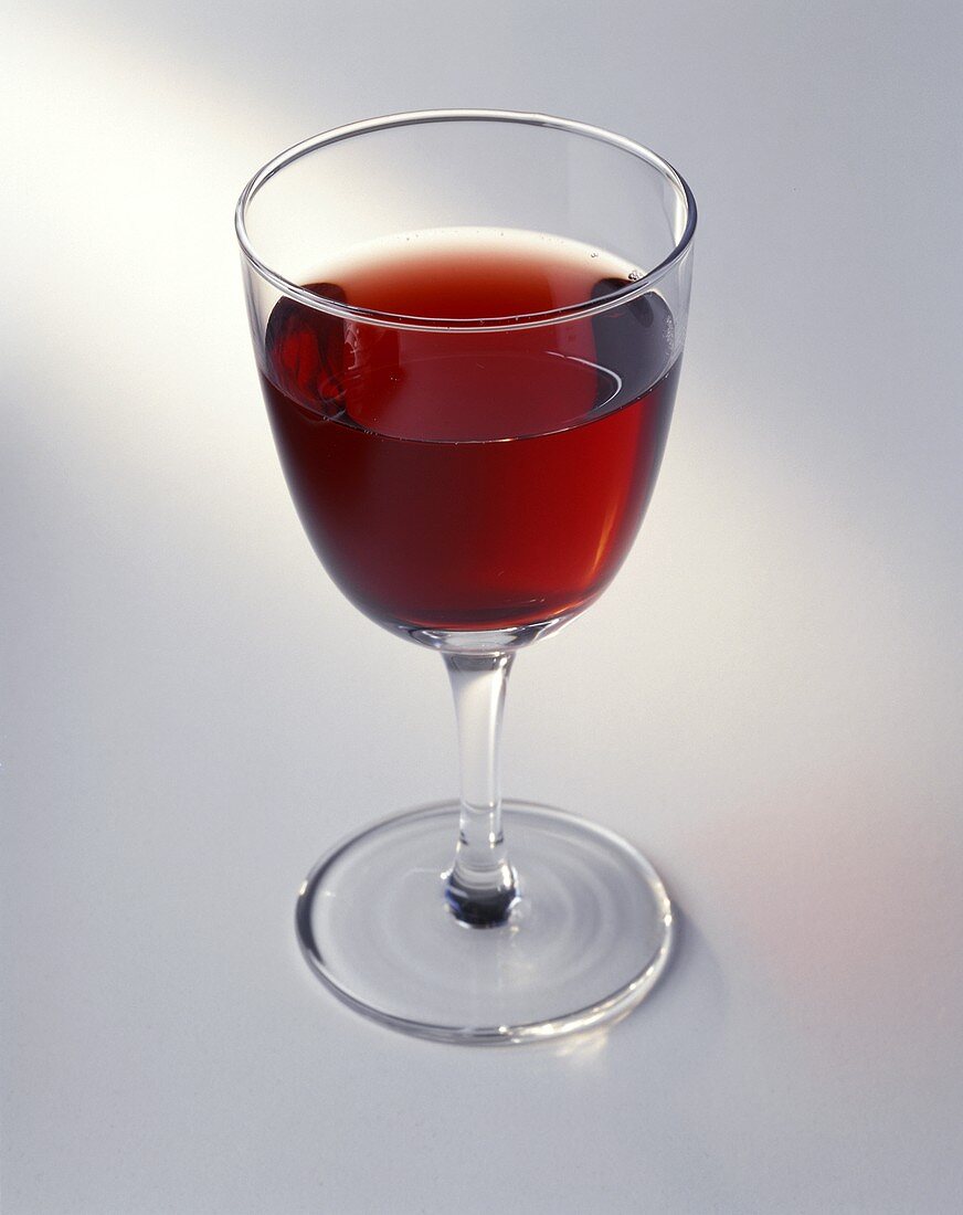 Ein Glas Rotwein auf hellem Untergrund