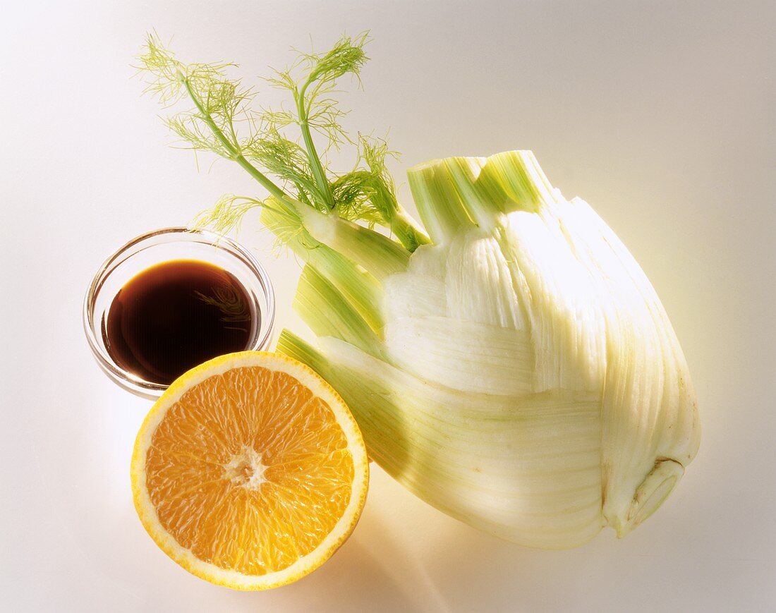 Fennel, half an orange and soy sauce in bowl