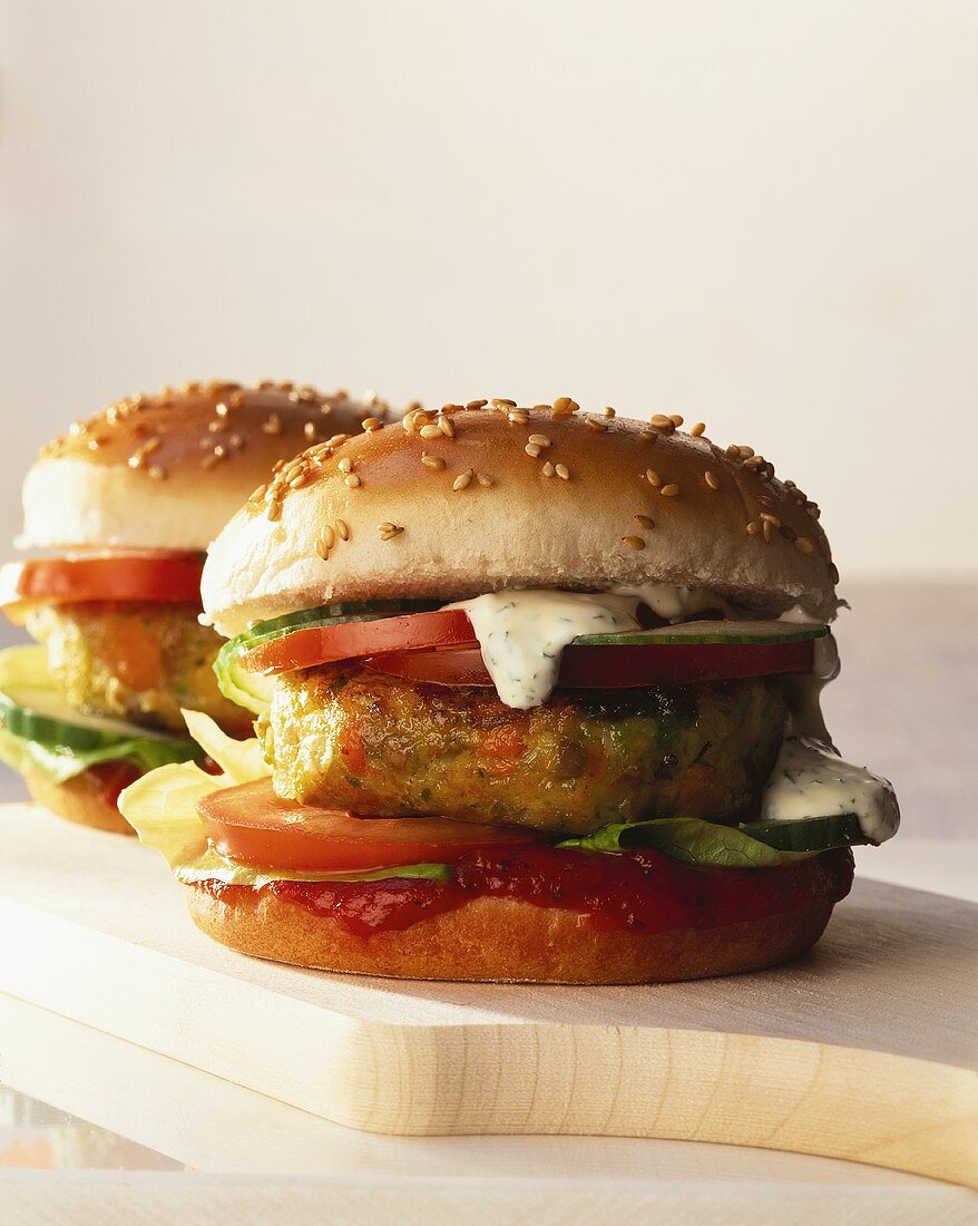 Vegetable burger with tomatoes, cucumber etc on chopping board 