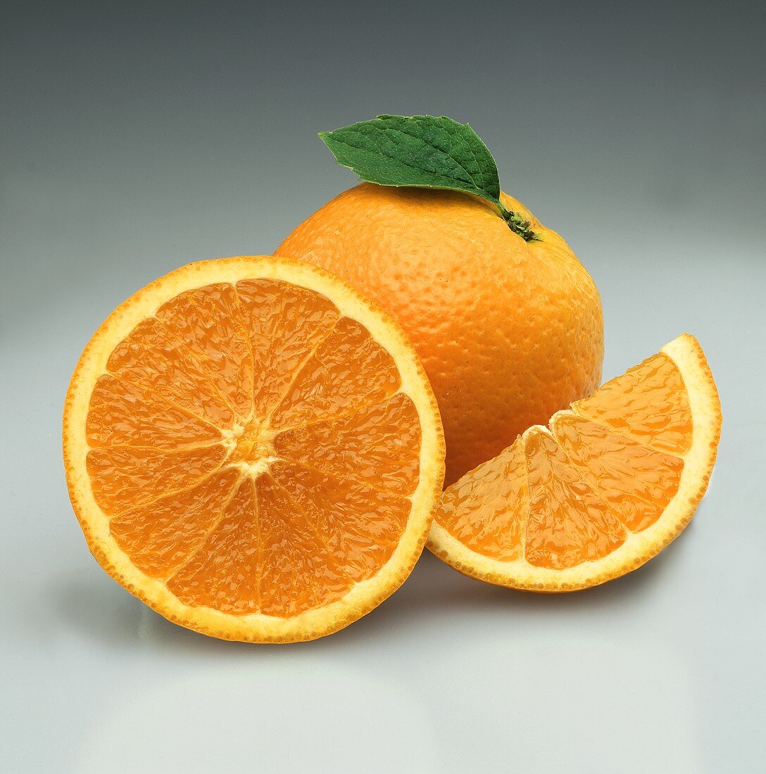 Orangen: ganze Orange, halbierte Orange und Orangenschnitz