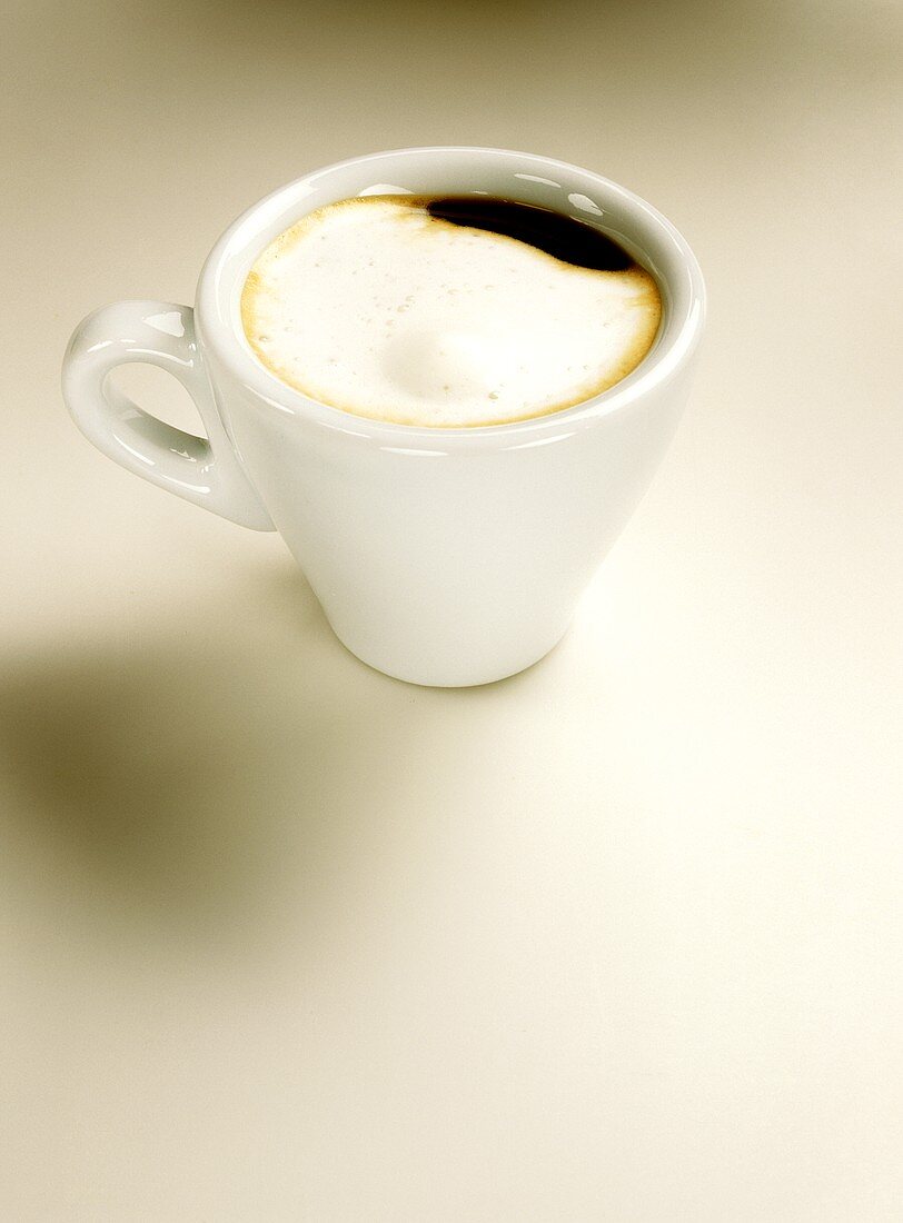 Caffè macchiato (with milk froth) in white espresso cup