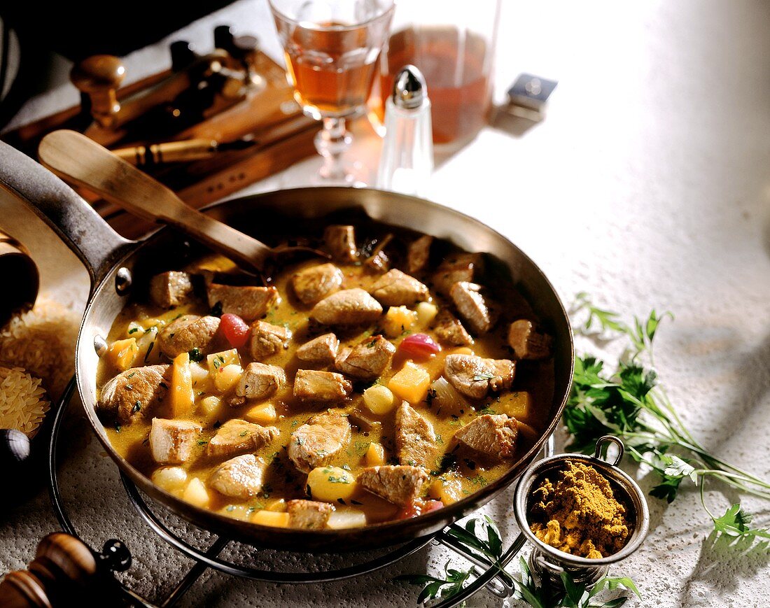 Curried veal fillet with fruit in frying pan