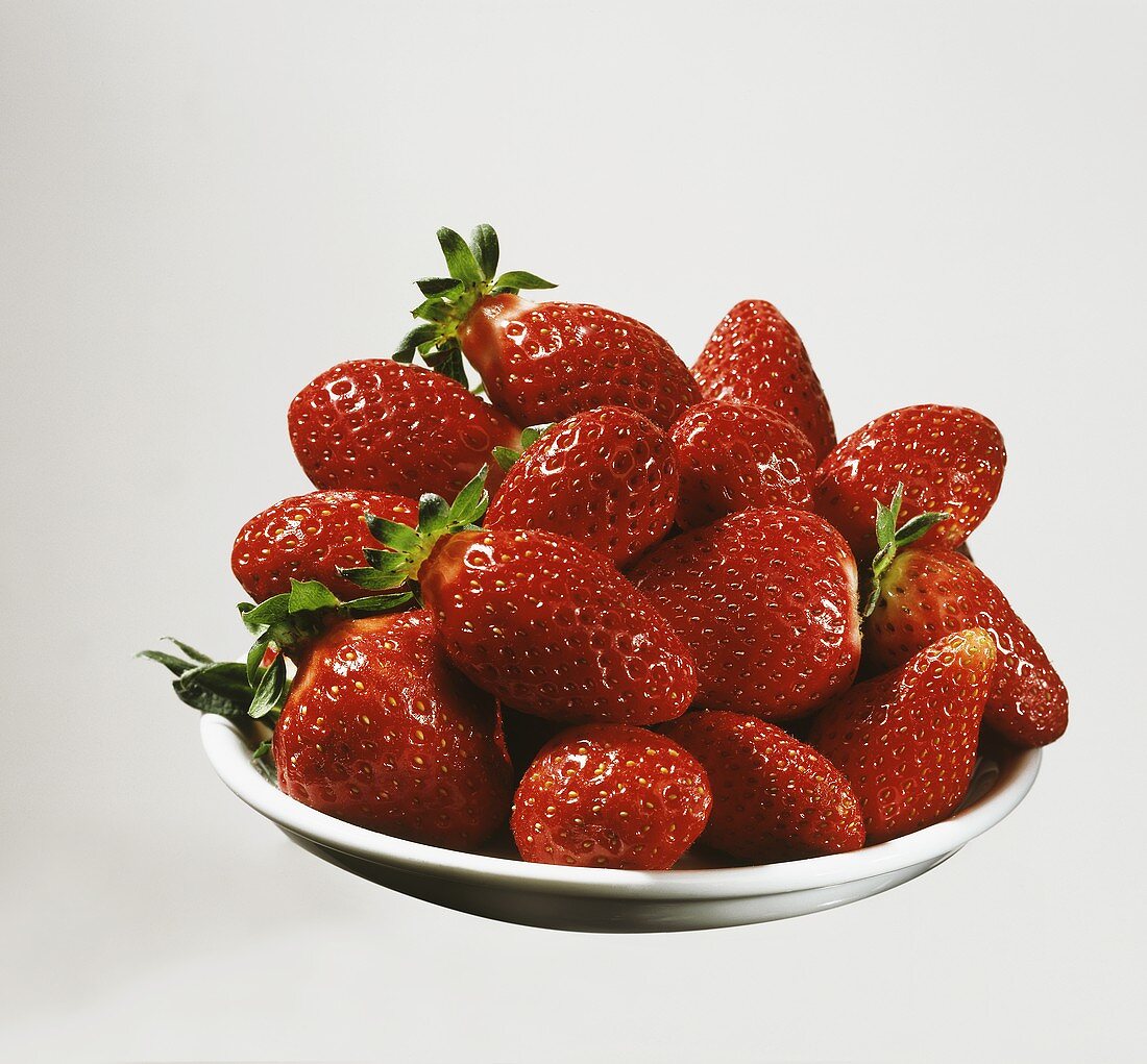 Erdbeeren gehäuft auf weißem Teller