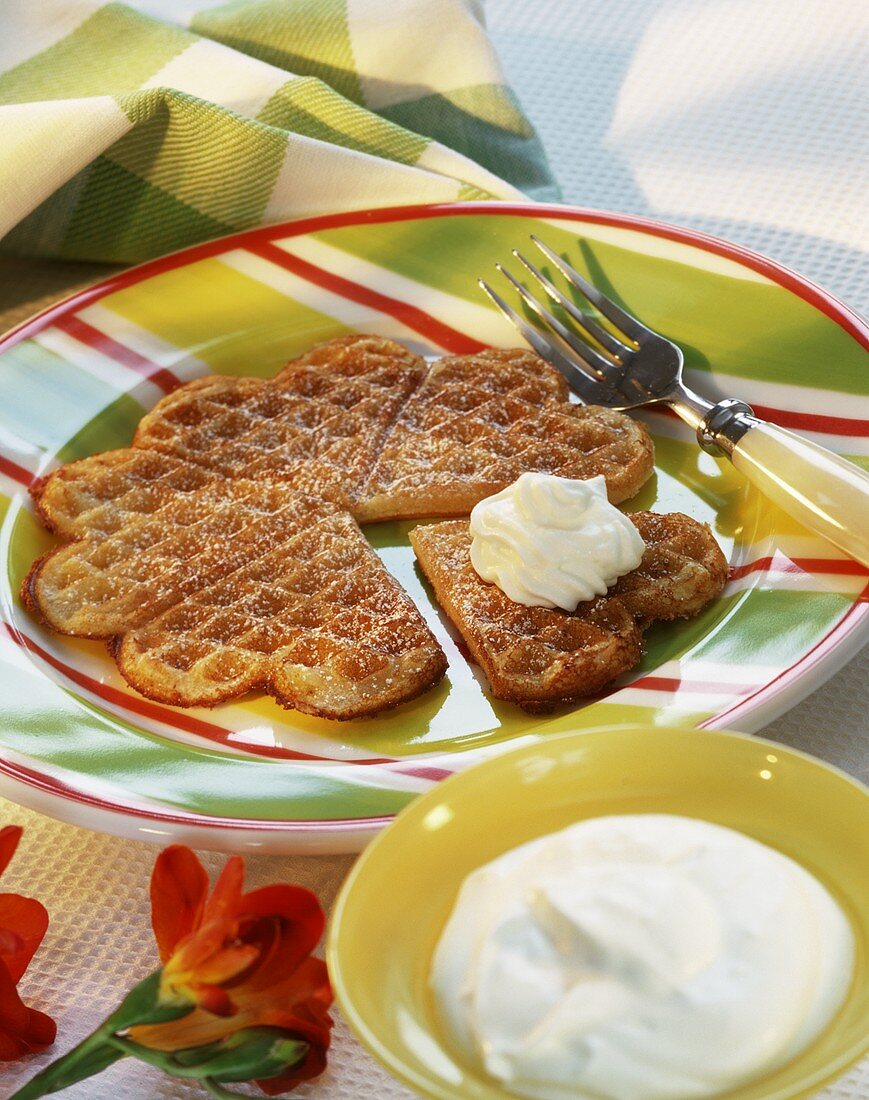 Heart-shaped Brussels waffles with icing sugar and cream
