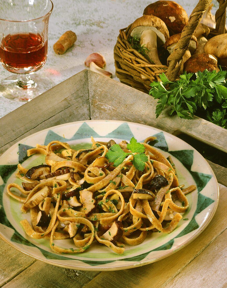 Wholemeal ribbon pasta with ceps and parsley on plate