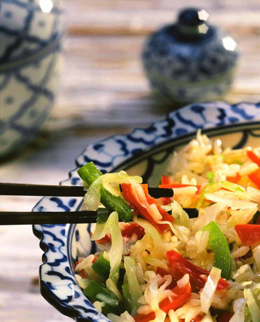 Reistopf mit Kohl und Paprikaschoten auf asiatischem Teller