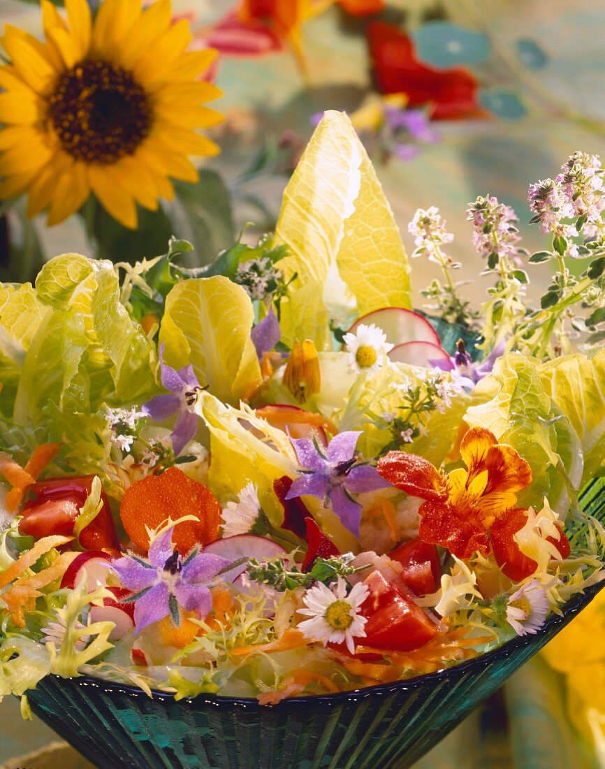 Gemischter Salat mit Blüten in grüner Schüssel