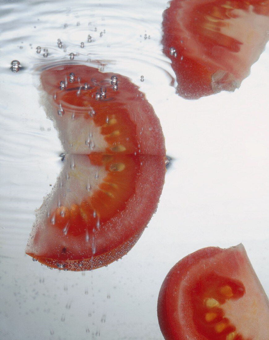 Tomatenschnitze fallen ins Wasser