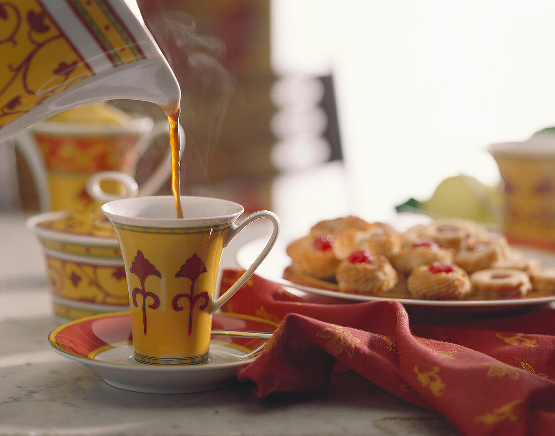 Pouring Hot Tea into Cup; Pastries