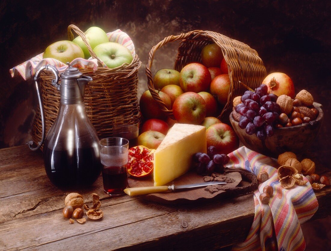 Herbstliches Stillleben mit Käse, Obst, Nüssen und Rotwein