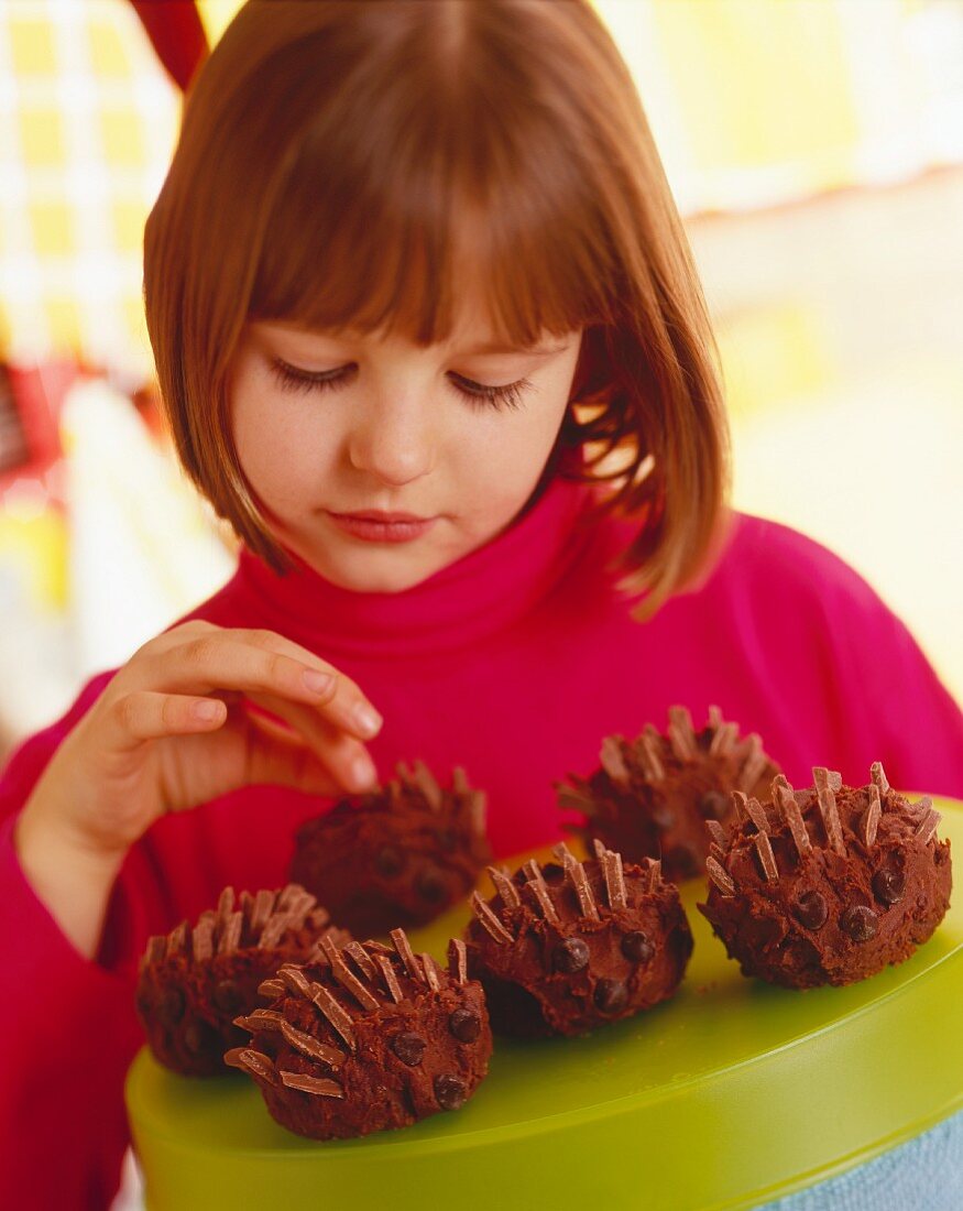 Child with Chocolate Desserts shaped like Porcupines