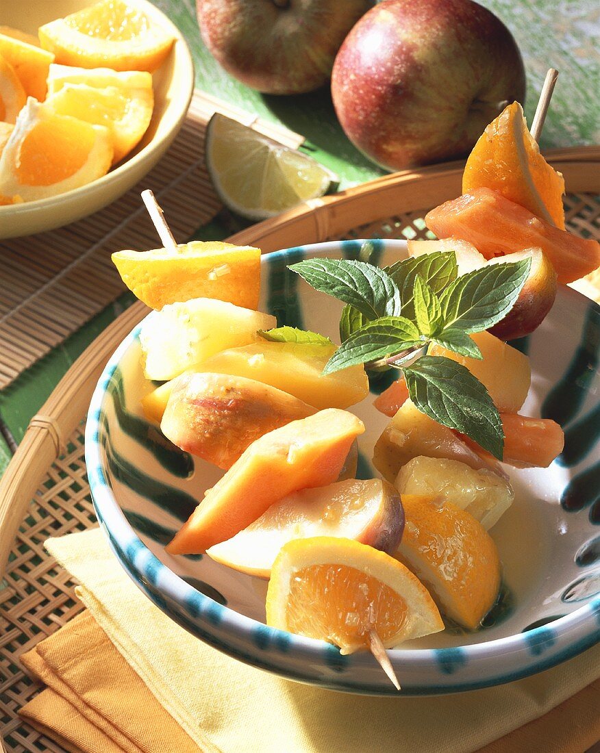 Fruit kebabs with ginger butter in a bowl