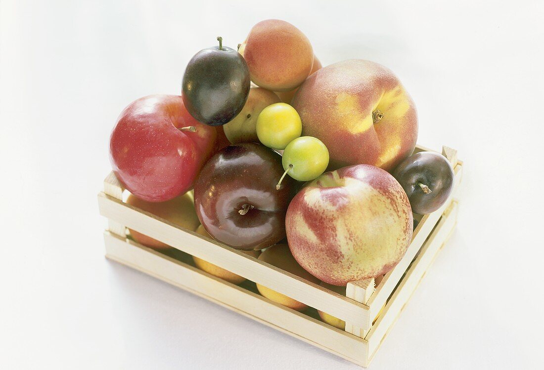 Various types of stone fruit in a crate