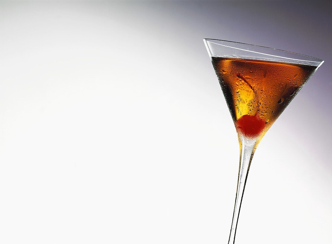 Manhattan Cocktail im Glas mit einer Cocktailkirsche