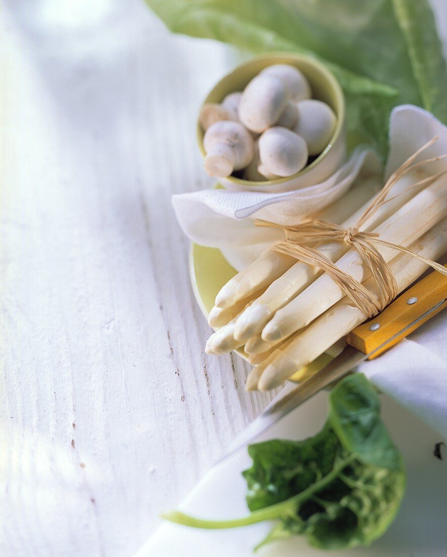 A bundle of white asparagus, mushrooms and spinach