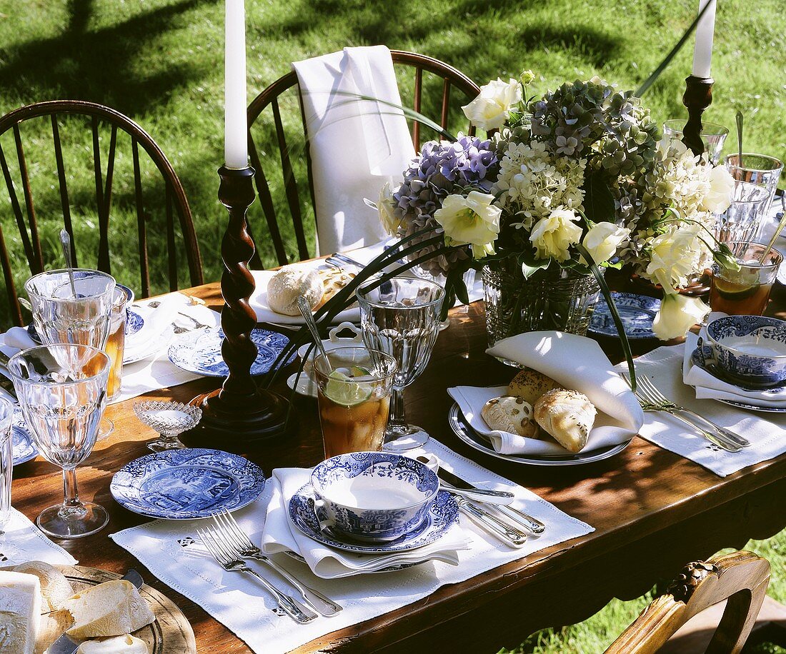 Laid table in open air with pastries, iced tea & lilac