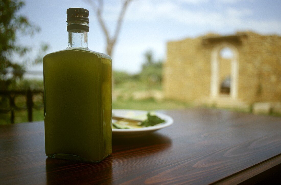 Olivenöl in einer Flasche auf Tisch im Freien