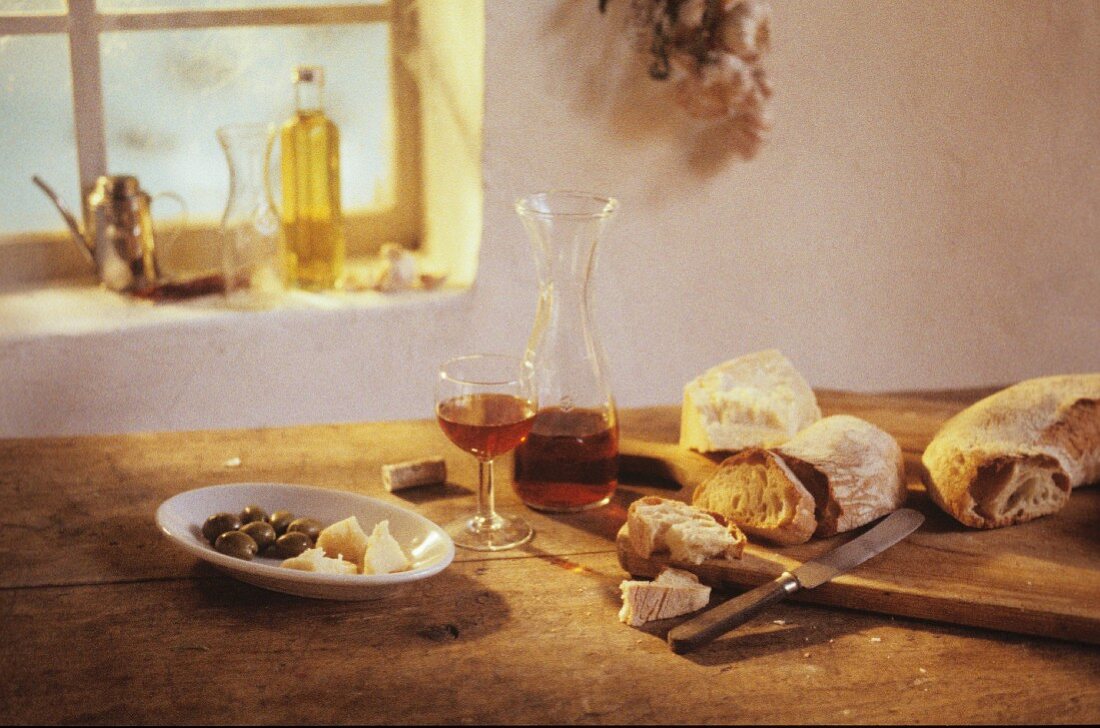 Vorspeisen, Rotwein, Parmesan und Weißbrot auf Holztisch