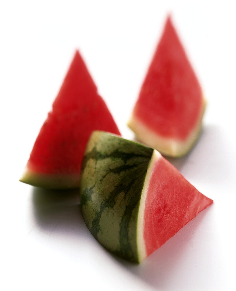 Three wedges of watermelon on white background