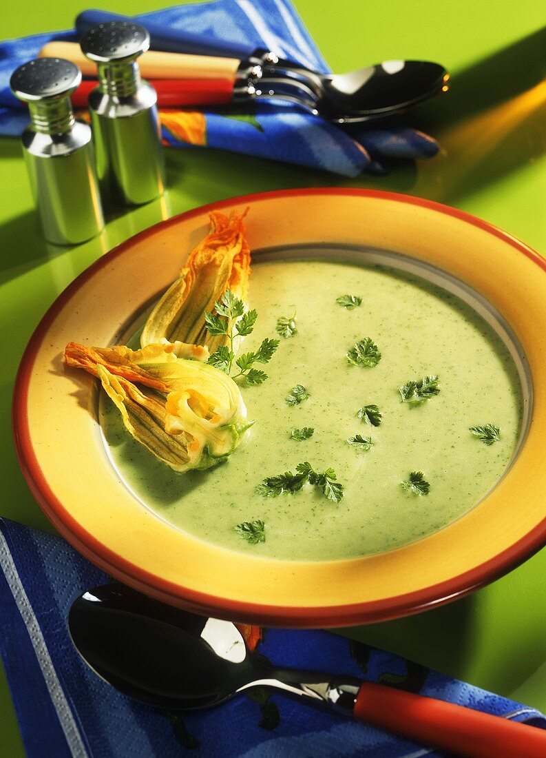 Zucchiniblütensuppe mit Kerbel auf gelbem Suppenteller