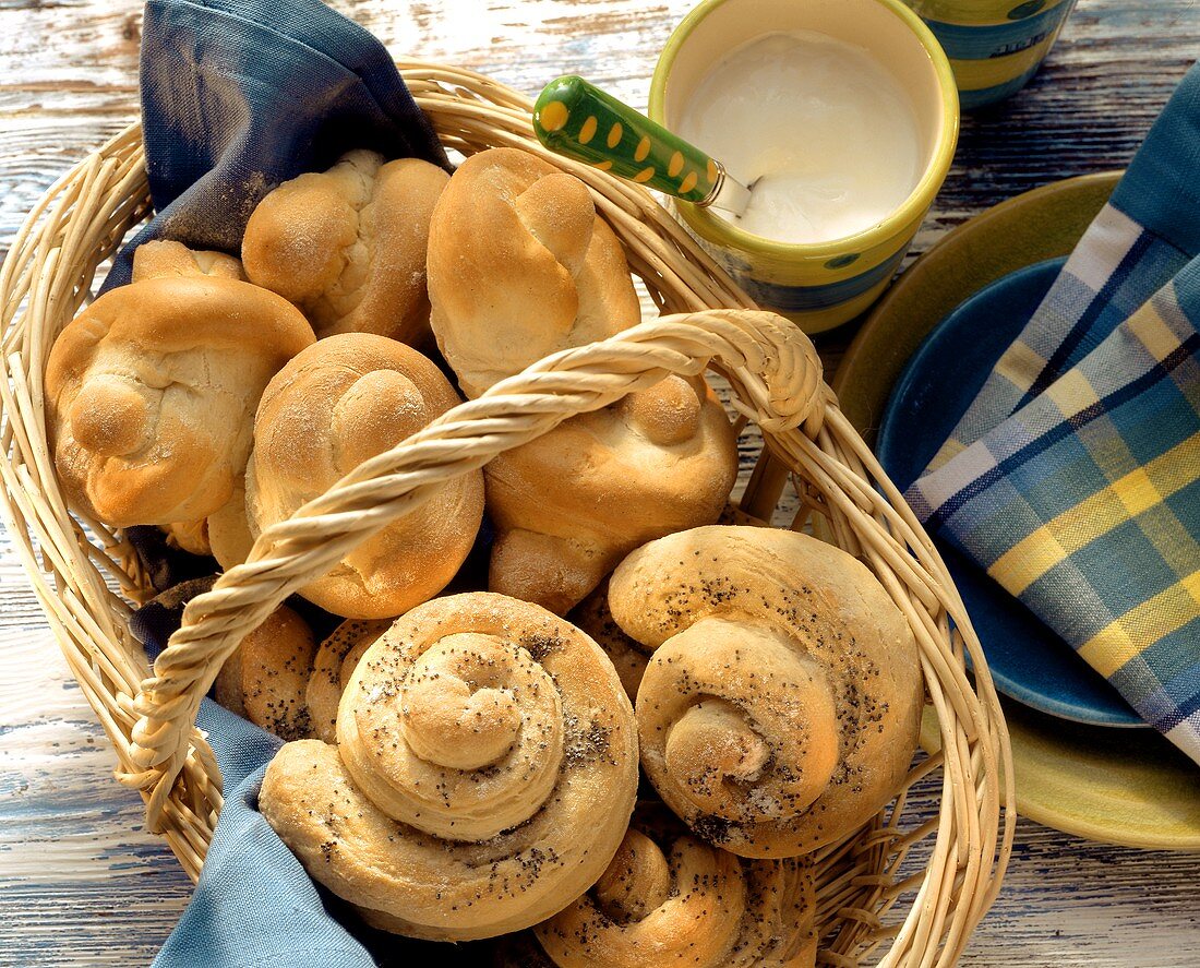 Quark rolls and yoghurt snails with poppy seeds in basket