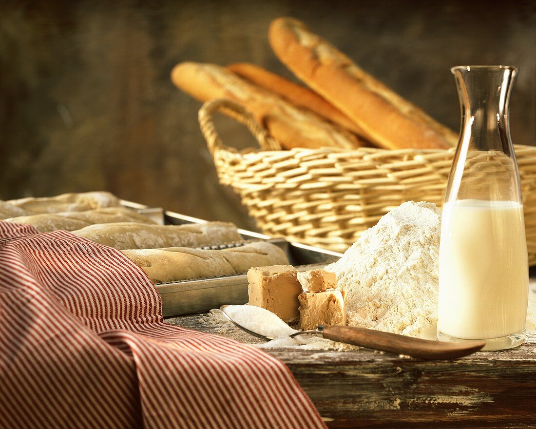Still life with flour, yeast, milk, sugar and baguettes