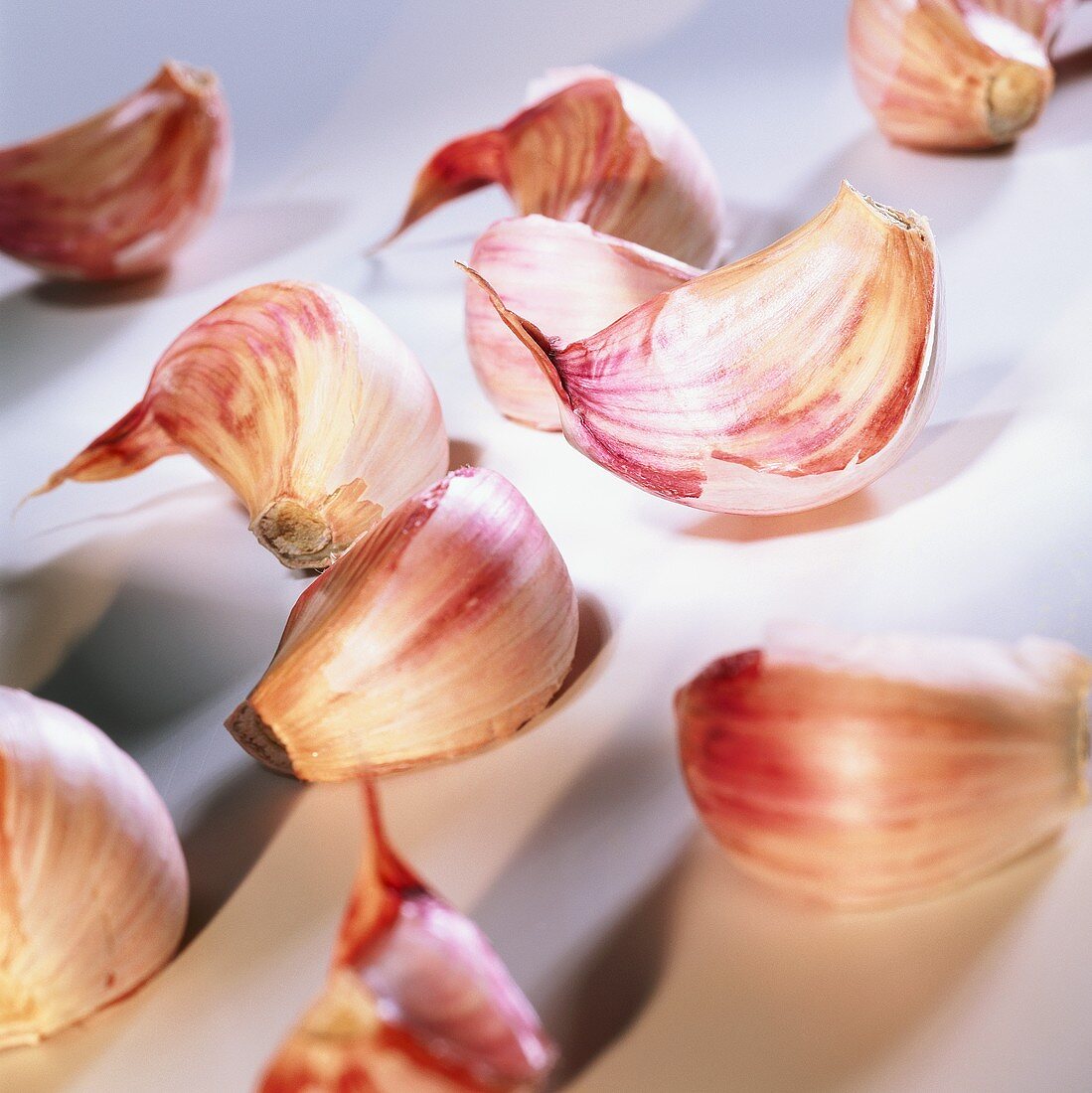 Several garlic cloves on light background