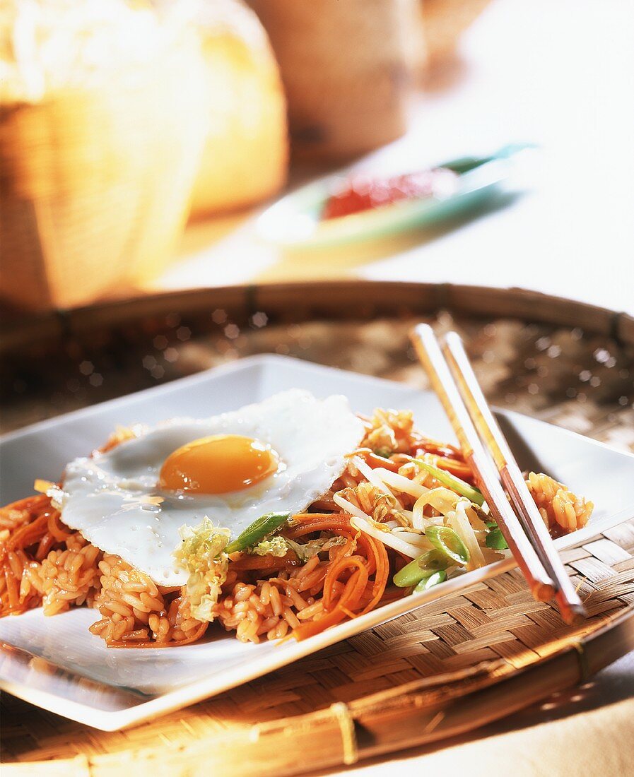 Nasi goreng with vegetables & fried egg on white plate