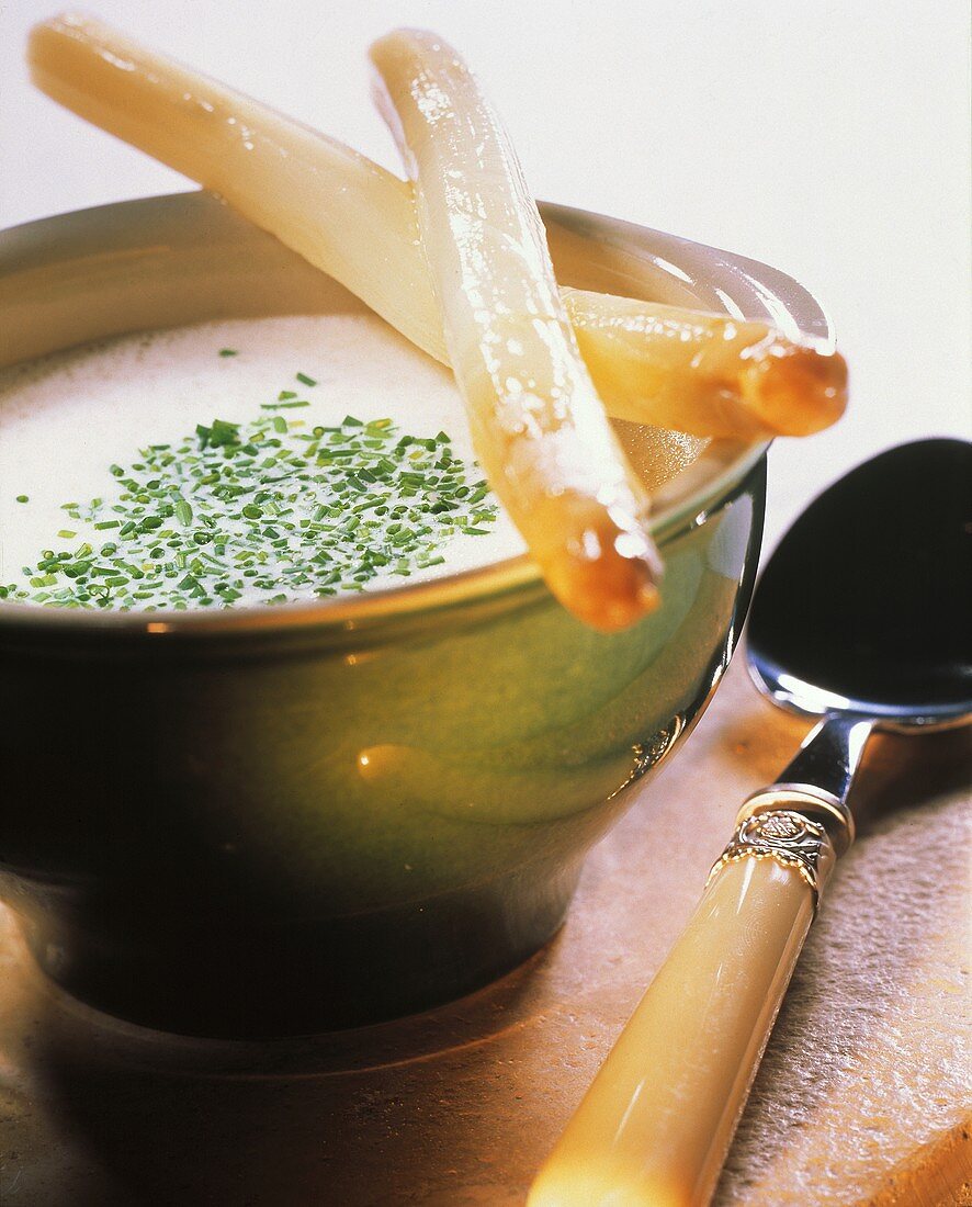 Asparagus cream soup with chives and white asparagus stalks