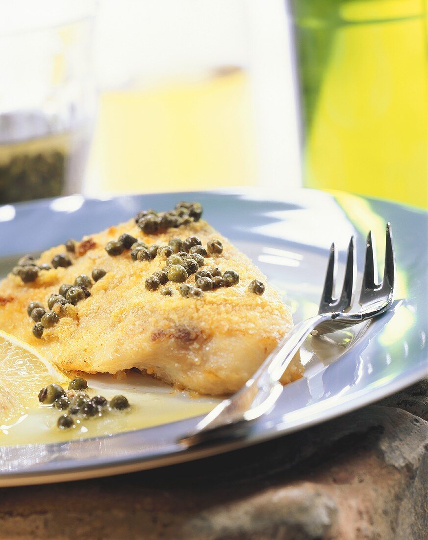 Oven-baked peppered fish with green peppercorns on plate
