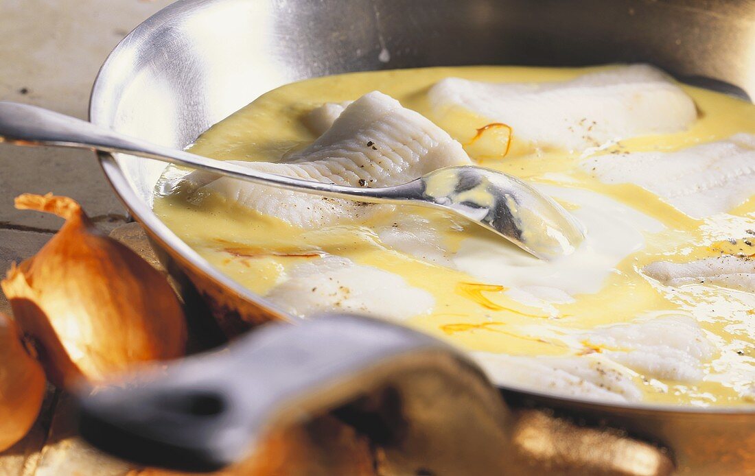 Plaice fillets in saffron cream in pan