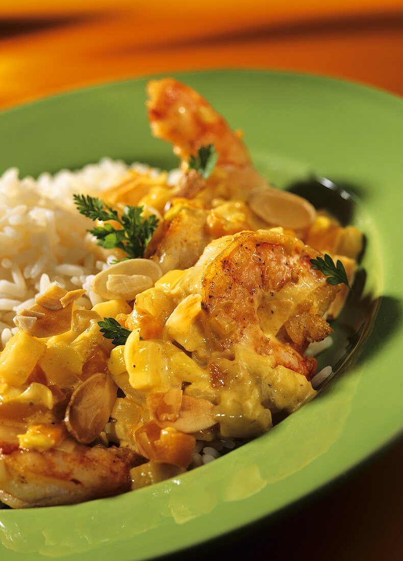 Shrimp curry with pineapple, almonds & rice on green plate