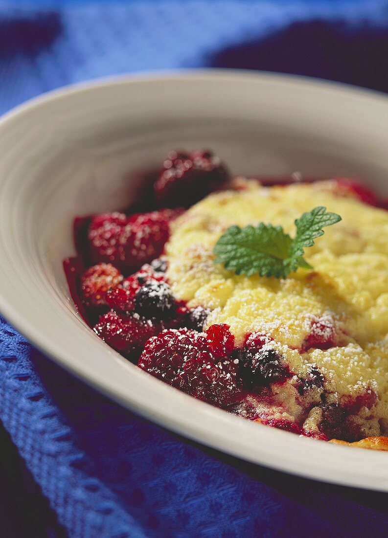 Überbackene Beeren mit Sektcreme, Puderzucker und Minzeblatt