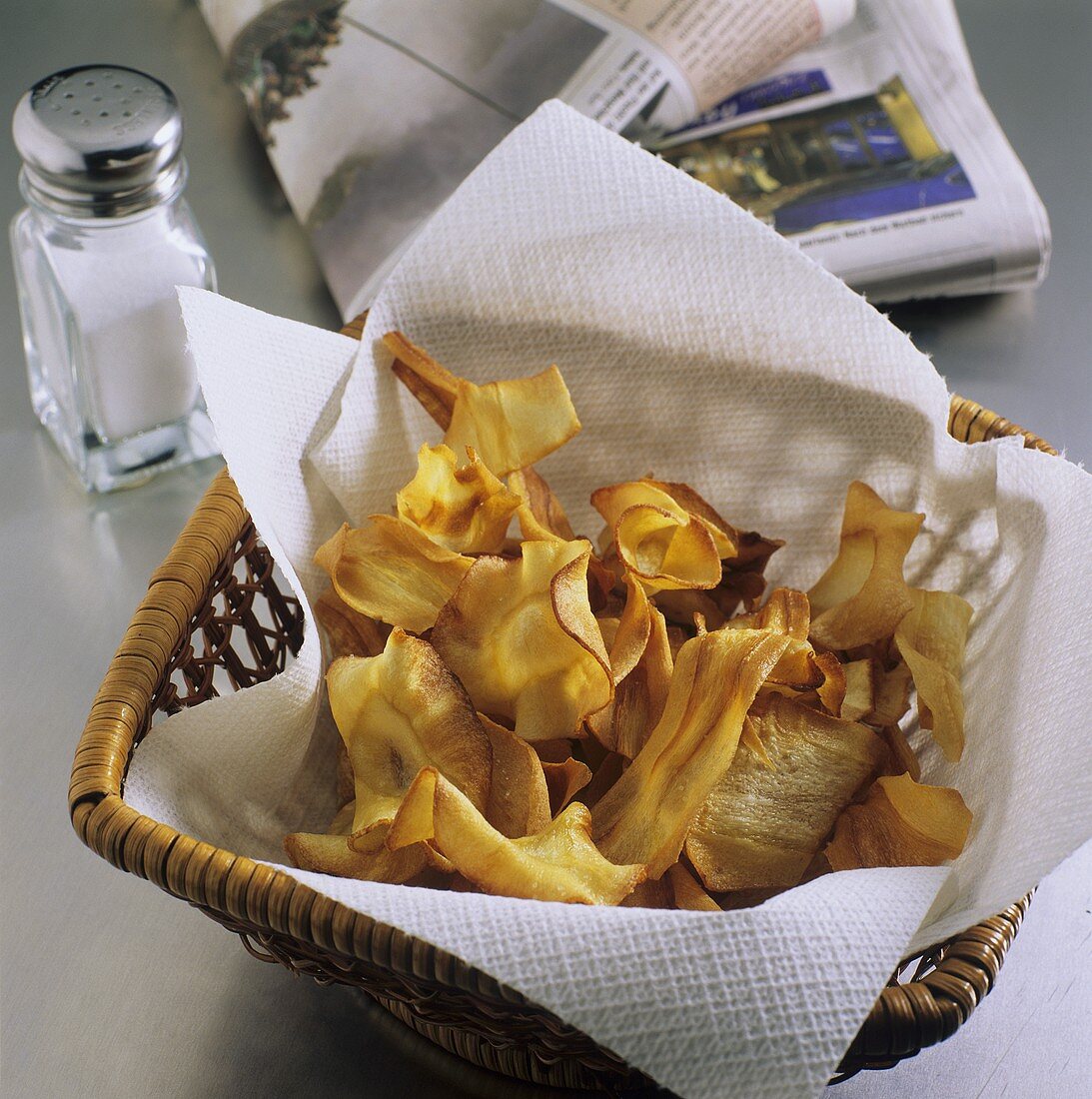 Deep-fried parsnip slices in a basket; Salt cellar