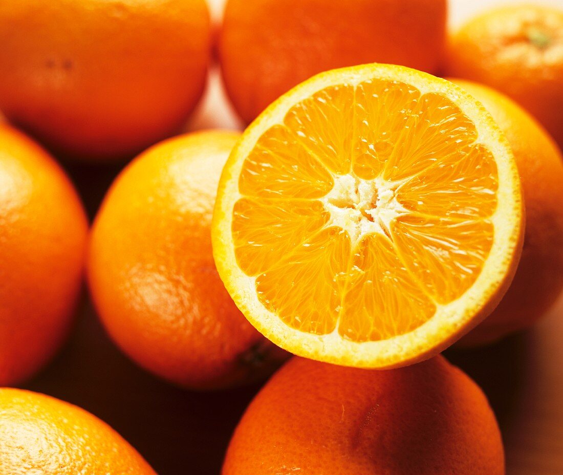 Eine Orangenhälfte auf einigen ganzen Orangen