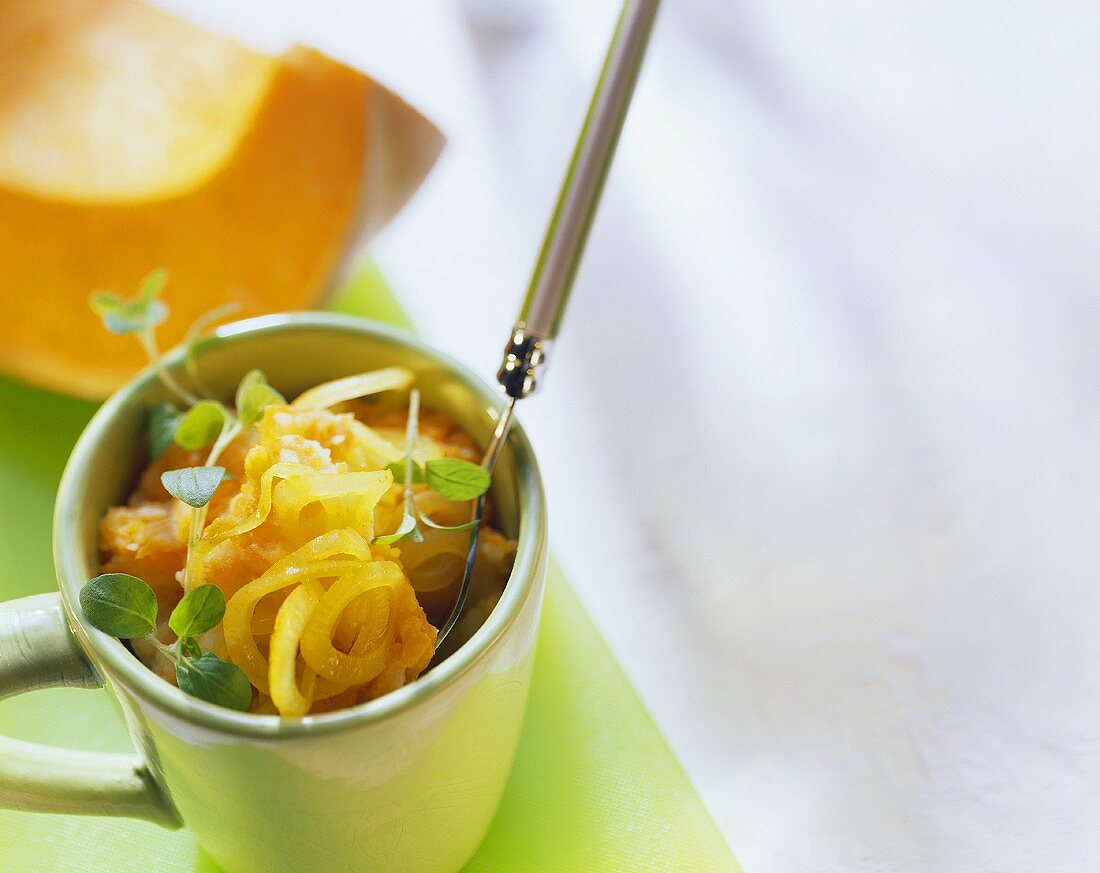 Pumpkin with onions and marjoram in mug with fork