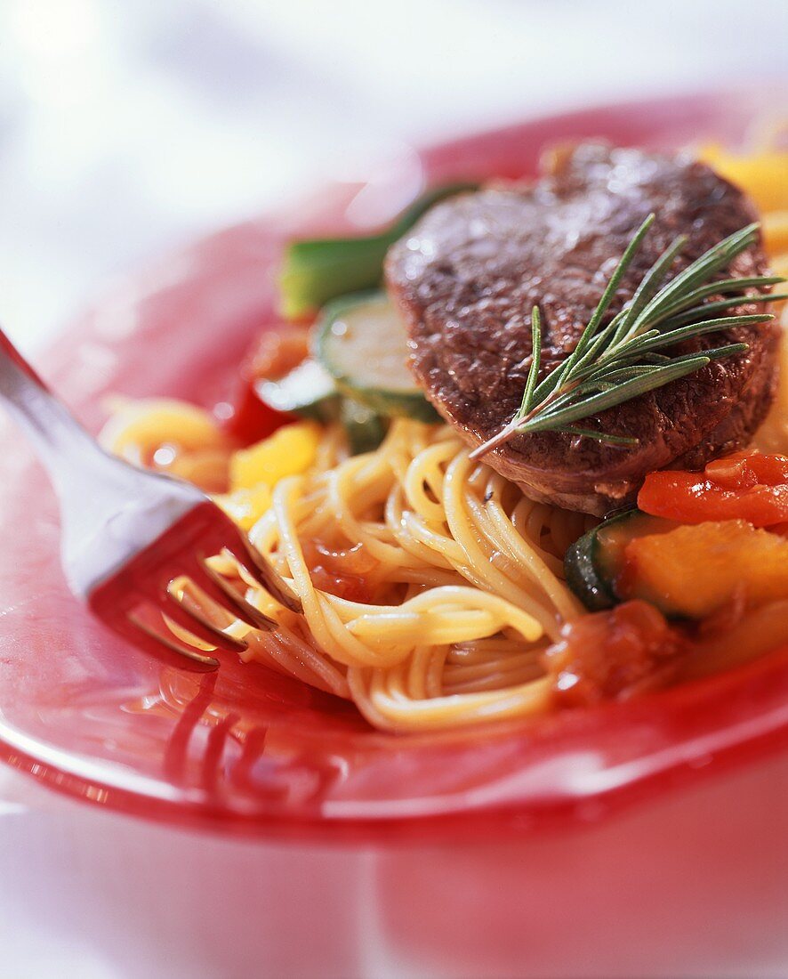 Filetsteak mit Spaghetti, Zucchini, Rosmarin auf Teller